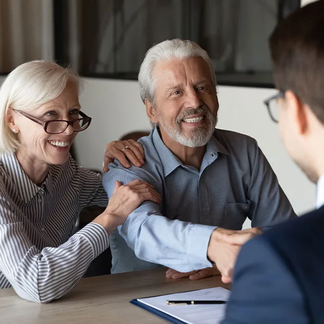 couple shaking hands with employee