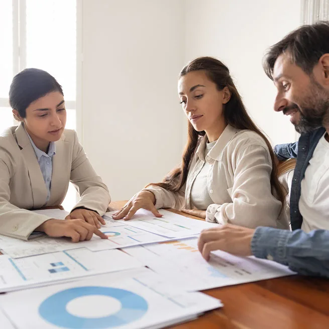 person speaking with couple about finances and looking through data